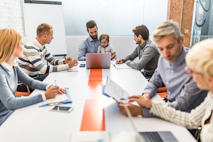 reunião empresarial e há um pai com filho no colo 