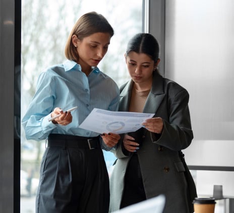 Duas jovens lendo um relatorio 