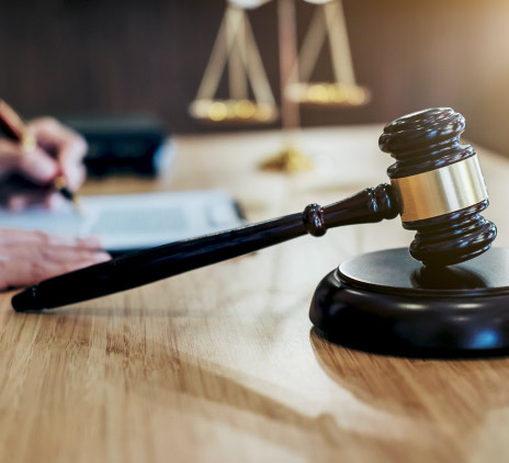 Mesa de um juiz com martelo em destaque