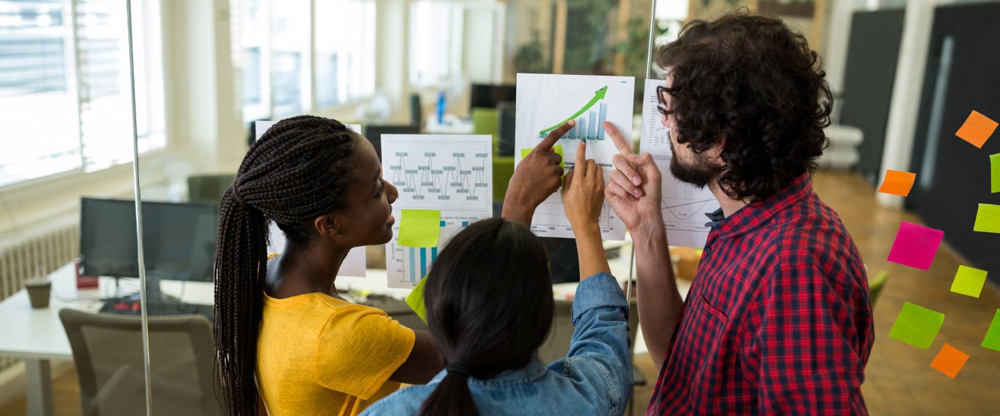 Grupo de designers gráficos que interagem sobre um gráfico