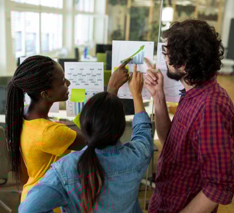 Grupo de designers gráficos que interagem sobre um gráfico