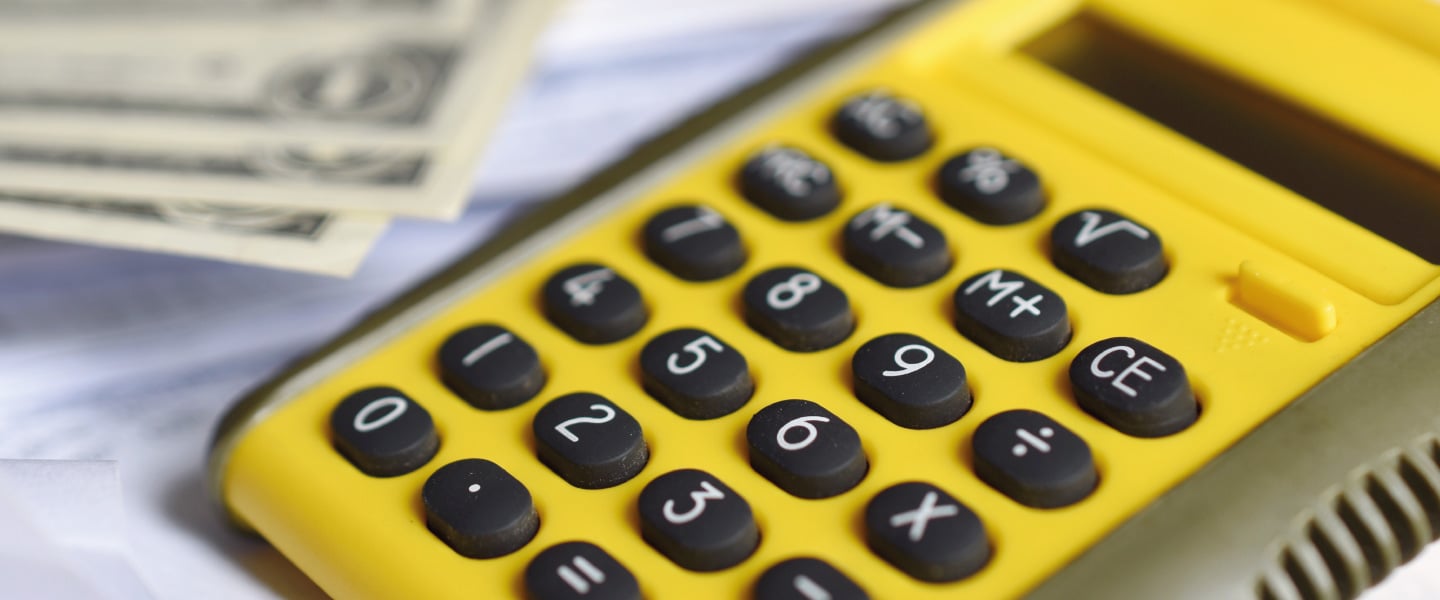 Calculadora amarela com papeis em volta