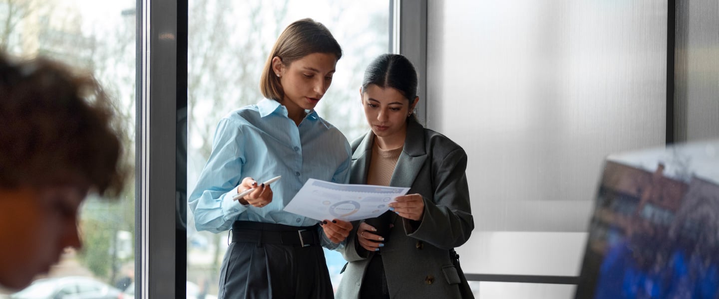 Duas jovens lendo relatório 