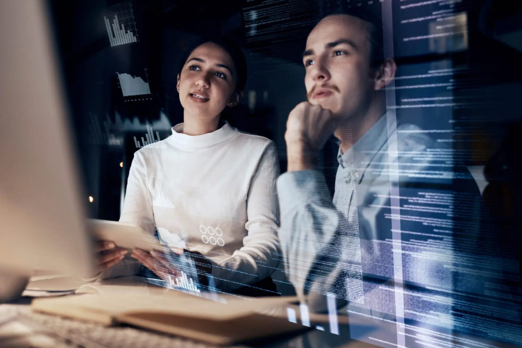 Dois jovens analisando tela de computador 