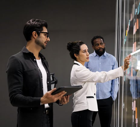Equipe analisando quadro com anotações