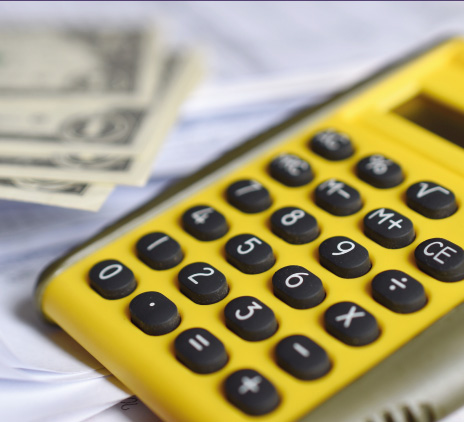 Calculadora amarela com papeis em volta 