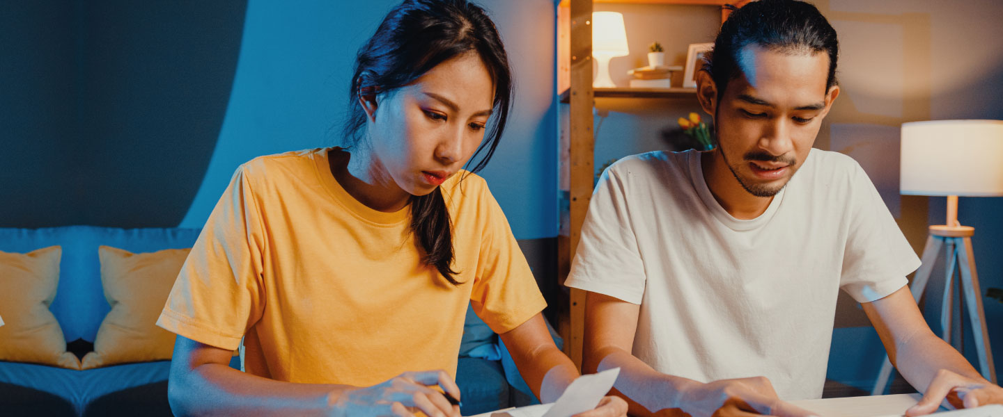 Casal de asiáticos usam calculadora para calcular o orçamento familiar