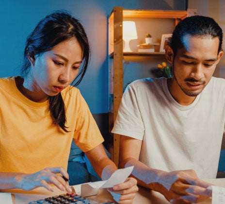 Casal de asiáticos usam calculadora para calcular o orçamento familiar