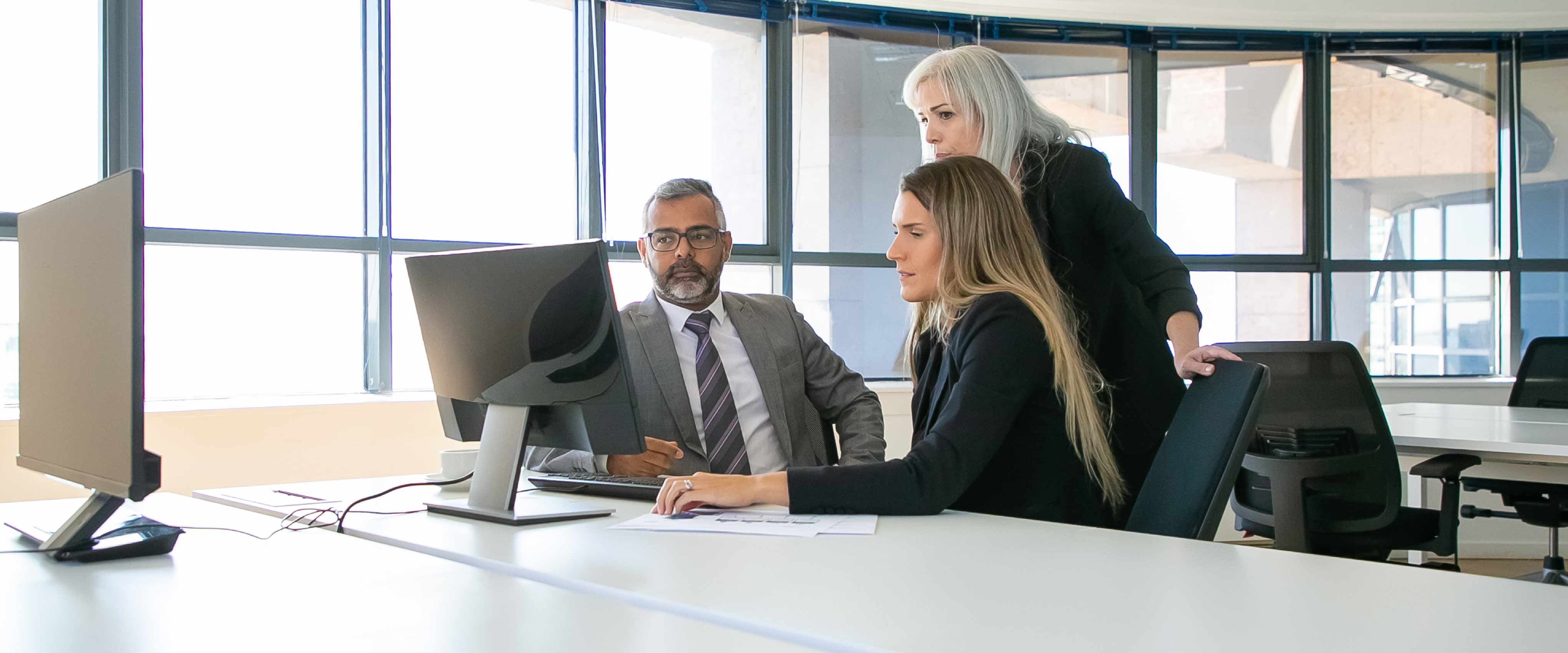 Gerentes da empresa discutindo a solução. Empresários se reunindo na sala de reuniões, assistindo conteúdo no monitor do computador juntos.