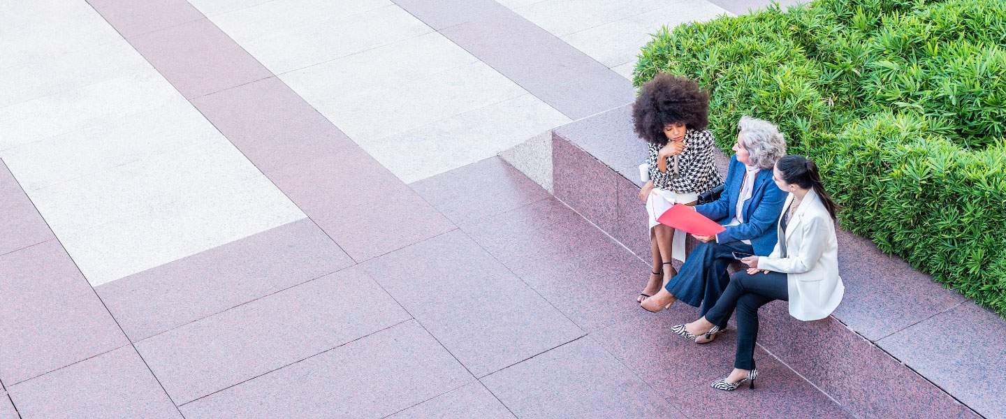 3 mulheres sentadas em um parque 